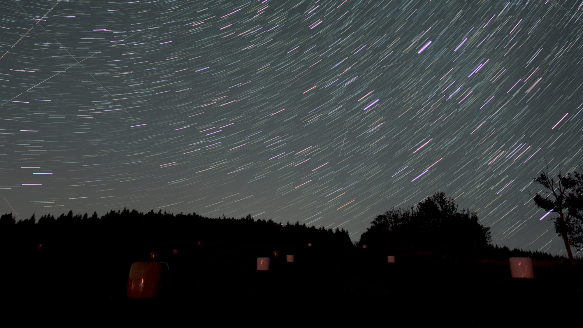 The same thirty frames in a plain lighten stack, with aircraft tracks and brighter sky